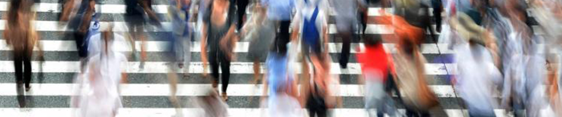 blurred people crossing a busy crosswalk